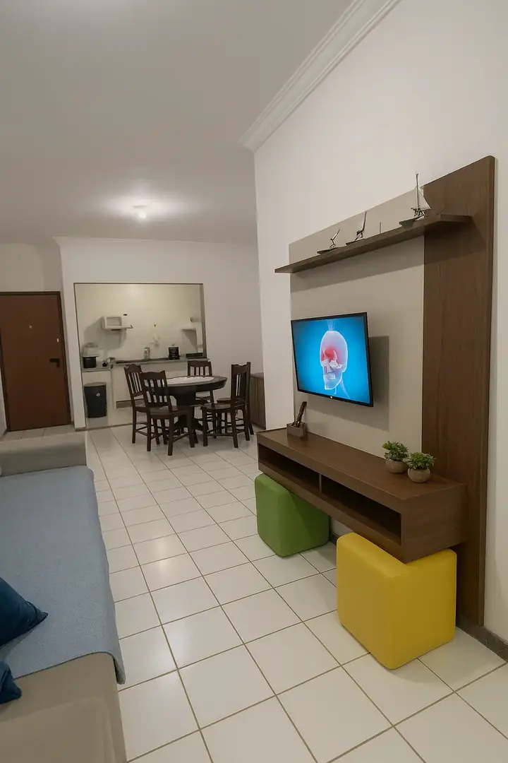 Sala do apartamento 901 com televisão e mesa